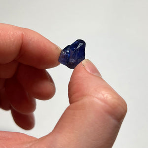 dark blue tanzanite crystal in hand