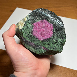 raw zoisite with ruby in hand 